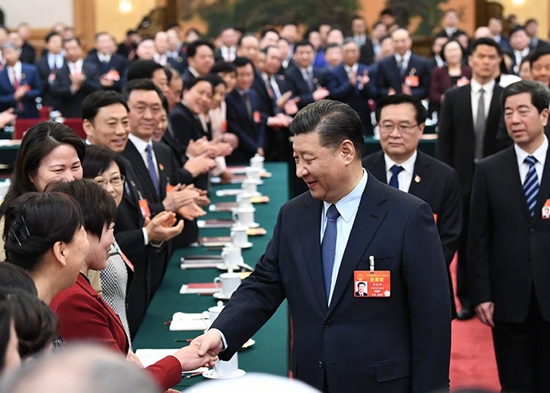 2019年3月8日，中共中央总书记、国家主席、中央军委主席习近平参加十三届全国人大二次会议河南代表团的审议。在“三八”国际劳动妇女节到来之际，习近平代表党中央，向参加全国两会的女代表、女委员、女工作人员，向全国各族各界妇女，致以节日的祝贺和美好的祝福。这是习近平同女代表亲切握手。新华社记者 谢环驰摄